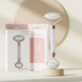 Face and neck massager roller displayed with elegant packaging on a minimalist background.