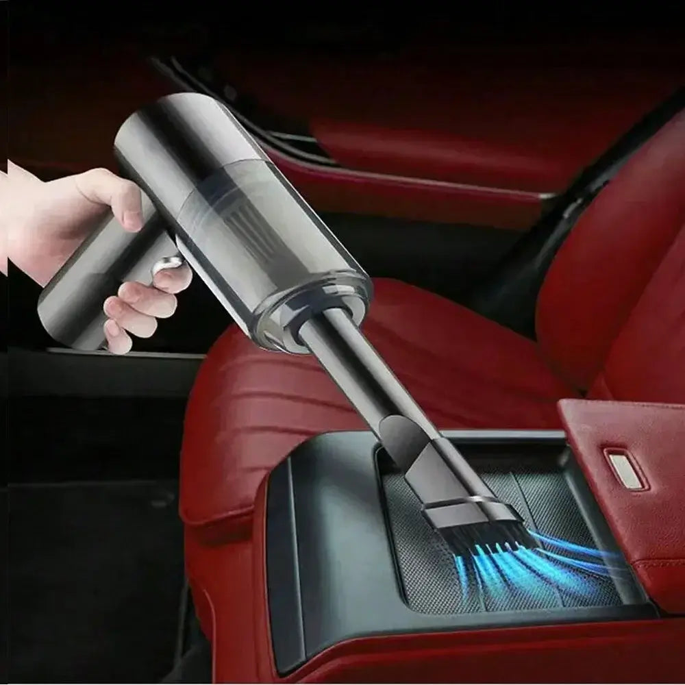 Handheld vacuum cleaner being used to clean car seats with powerful suction and integrated brush.