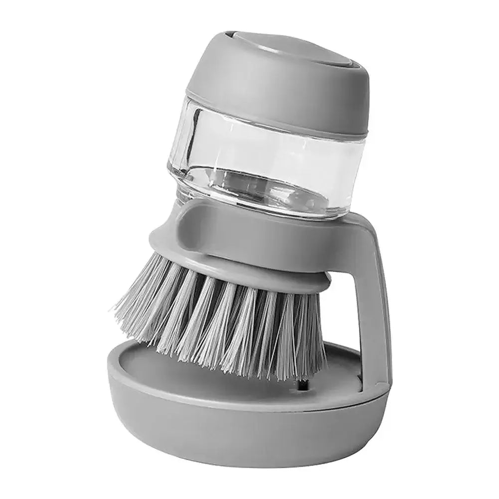 Multifunctional gray cleaning brush with soap dispenser for kitchen scrubbing pots and pans.