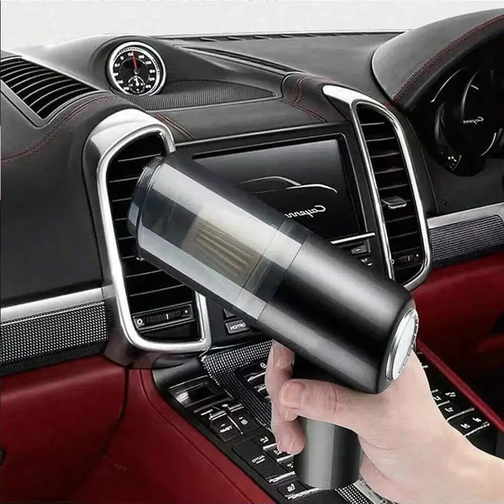 Handheld vacuum cleaner being used to clean car seats with powerful suction and integrated brush.